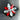 Floral jewelry piece with red and clear gemstones on a reflective surface