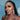 A pair of clear ab pave rhinestone dangle bikini jewelry earrings displayed by an npc bikini fit model.