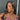 A pair of silver floral dangle bikini jewelry earrings adorned with AB rhinestones, displayed by an npc bikini fit model.