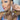A pair of clear rhinestone statement bikini jewelry earrings with a silver finish, featuring a intricate drop design, displayed by an npc bikini fit model.
