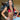 A pair of clear silver teardrop rhinestone bikini jewelry earrings displayed by an npc bikini fit model.